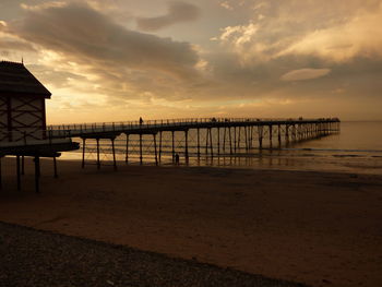 Pier on sea at sunset