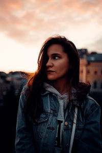 Portrait of beautiful woman standing against sky during sunset