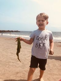 Full length of boy on beach against sky