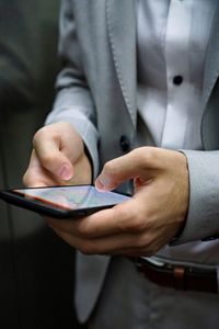 Midsection of man using mobile phone