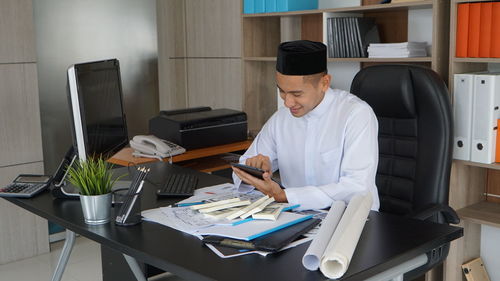 Side view of man working at desk in office