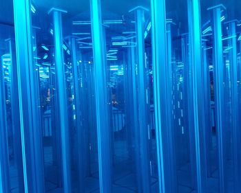 Low angle view of illuminated lighting equipment on blue surface