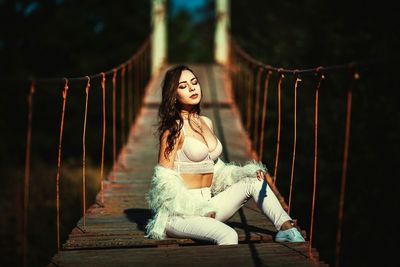 Young woman looking away against trees