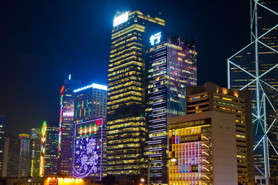 Low angle view of illuminated buildings against sky at night