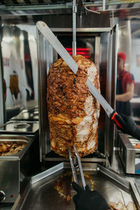 Meat on a speat.  beaf. pork. kebab. big knife ready to cut it.