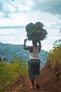 Rear view of woman standing against trees