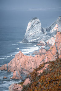 Rock formations in sea against sky