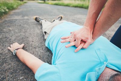 Man lying on road outdoors