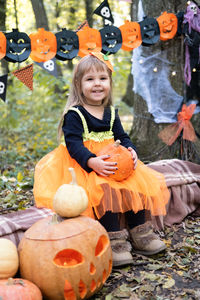 Halloween. cute girl in pumpkin costume with pumpkin outdoor, having fun, celebrating halloween