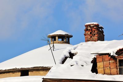 Low angle view of house roof and building against sky