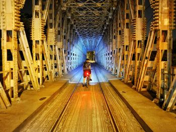 Rear view of man walking in tunnel