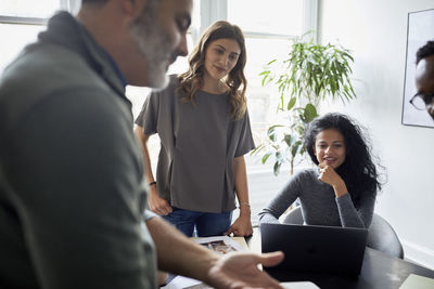 Businessman explaining to female colleagues in creative office