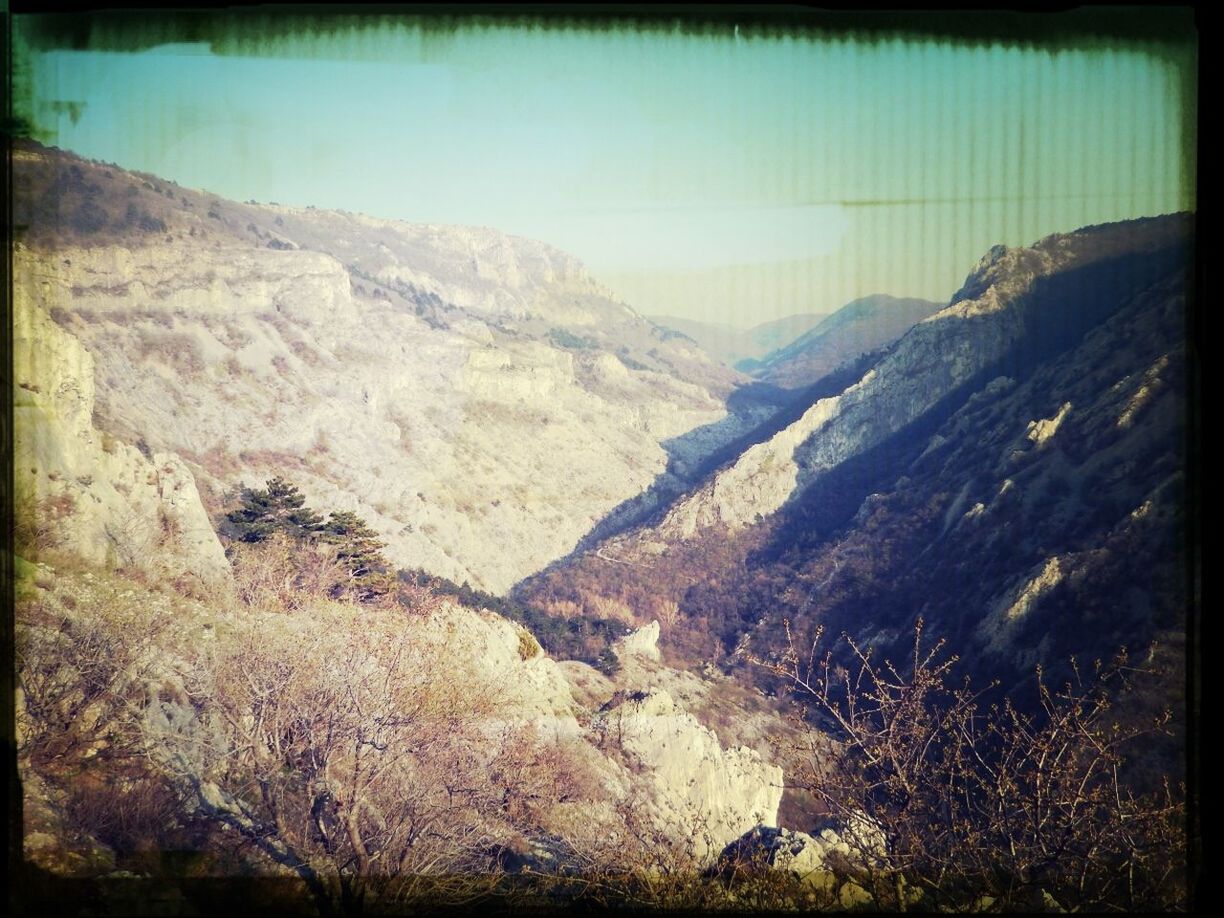 transfer print, mountain, tranquil scene, tranquility, scenics, clear sky, auto post production filter, rock formation, beauty in nature, landscape, nature, mountain range, rock - object, non-urban scene, sky, rock, physical geography, cliff, geology, idyllic