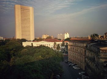 Buildings in city against cloudy sky