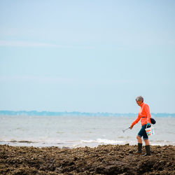 Man standing on beach against sky