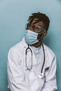 Close-up of doctor against colored background