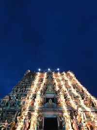 Low angle view of illuminated buildings against sky at night