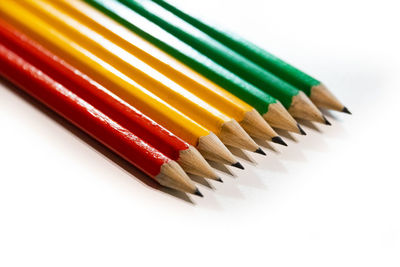 High angle view of colored pencils against white background