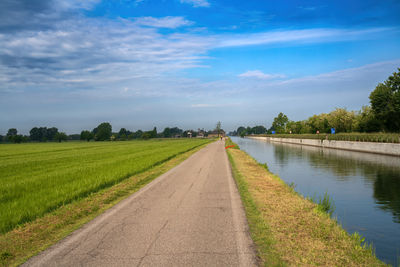 Road amidst field against sky