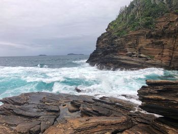 Scenic view of rocks in sea against sky