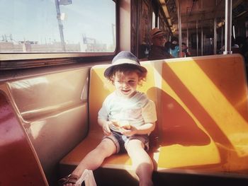 Full length of boy sitting in bus