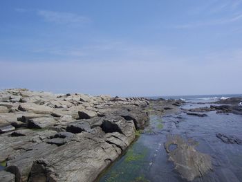 Rocks on beach against sky