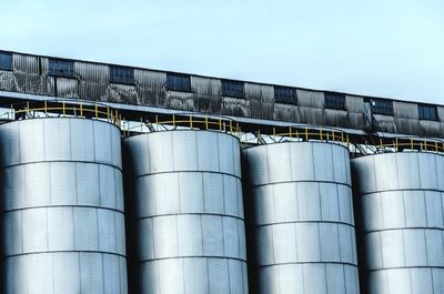 Low angle view of silos against sky