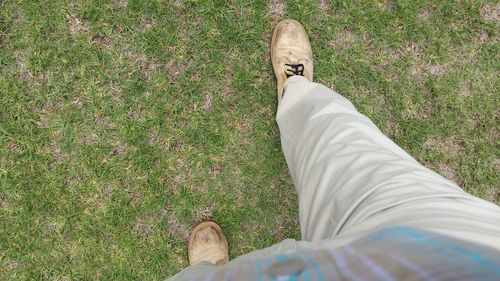 Low section of person standing on grassy field
