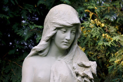 Close-up of angel statue against trees