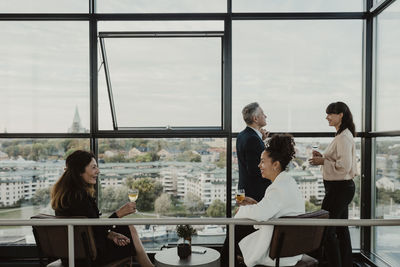 Happy male and female coworkers with wineglasses during office party