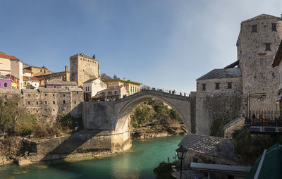 Arch bridge over river against sky