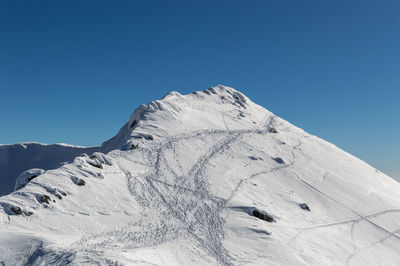 Scenic view of snowcapped mountains against clear blue sky