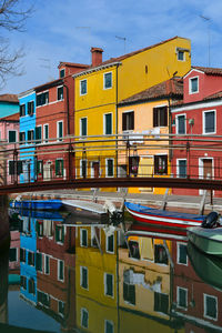 Boats moored in canal by buildings in city