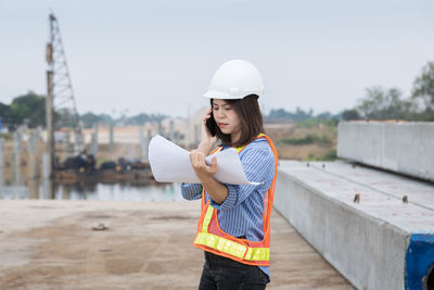 Young woman wearing hat standing at construction site