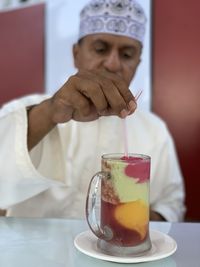 Midsection of man holding drink on table