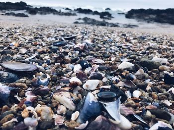 Close-up of pebbles on beach against sky