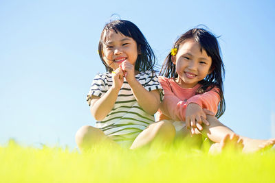 Portrait of smiling sibling against clear sky