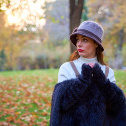 Young woman standing against trees