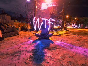 Man sitting on illuminated city at night