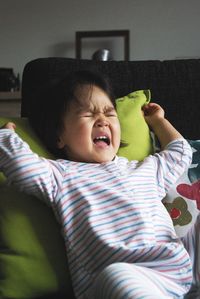 Portrait of cute baby girl lying on bed at home