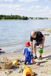 Grandfather playing on beach with grandson