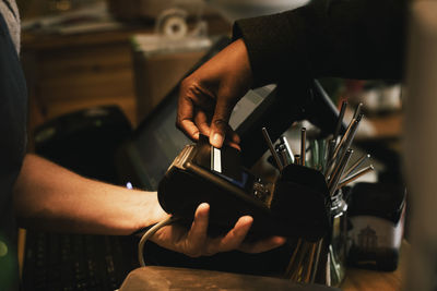 Cropped image of customer paying through credit card in store