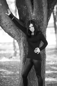 Portrait of woman with tree trunk