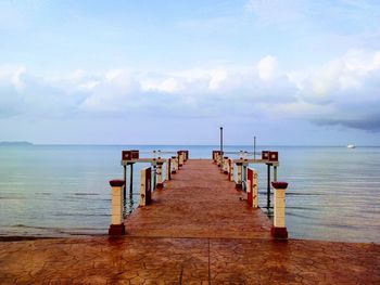 Wooden pier on sea against sky