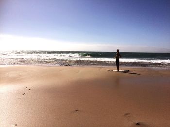 Men standing on beach against clear sky