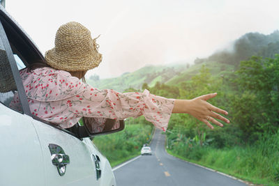 Rear view of woman with umbrella on road