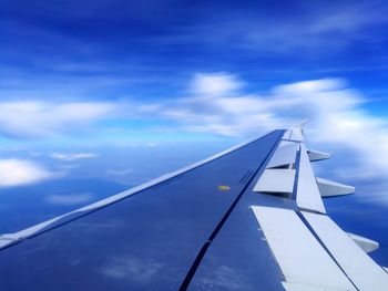 Low angle view of airplane wing against sky