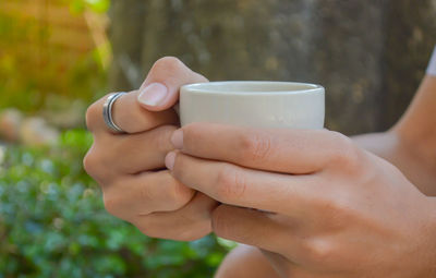 Close-up of hand holding coffee cup