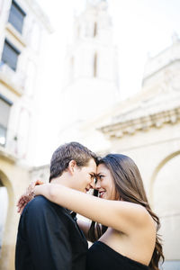 Couple embracing against historic building