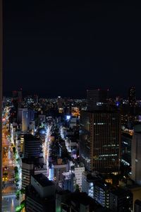 Illuminated cityscape against sky at night